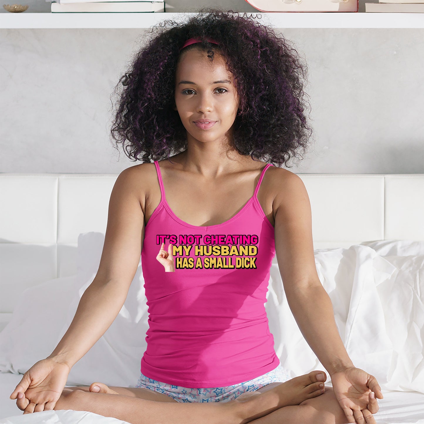 a woman in a pink tank top sitting on a bed